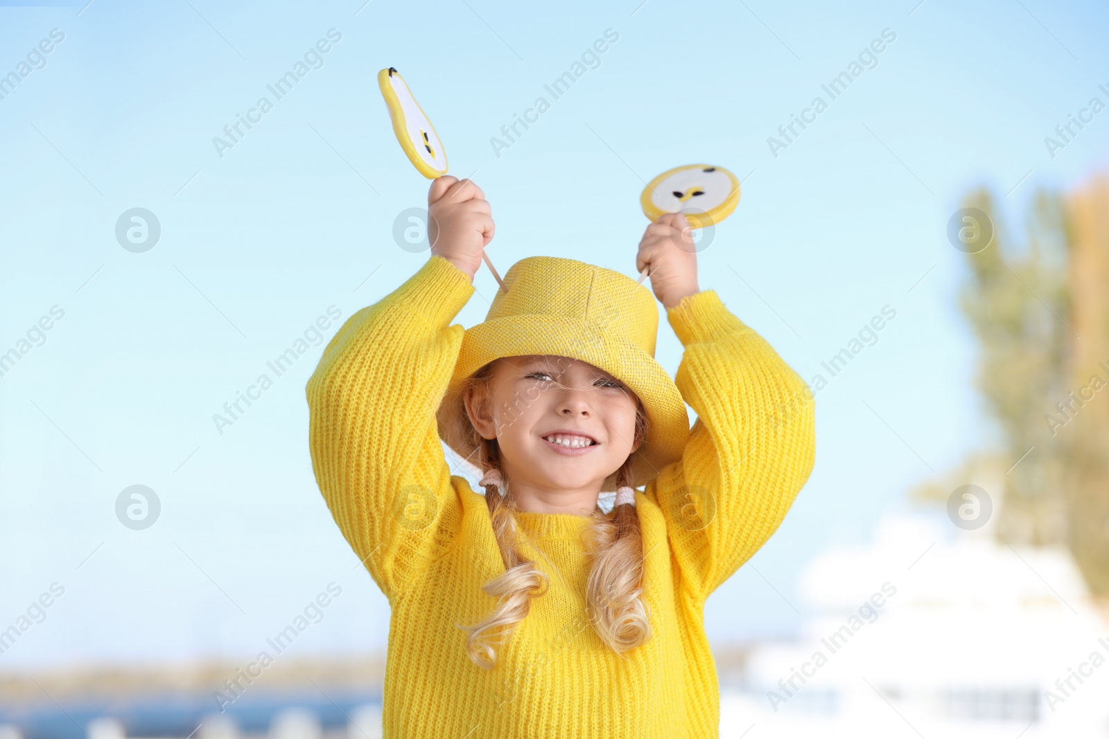 Photo of Cute little girl with tasty candies outdoors