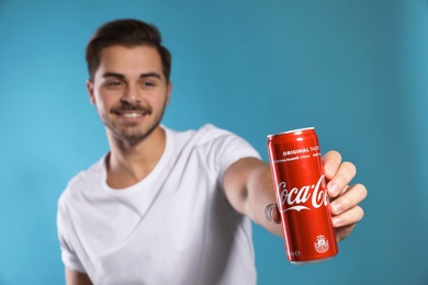 MYKOLAIV, UKRAINE - NOVEMBER 28, 2018: Young man with Coca-Cola can on color background