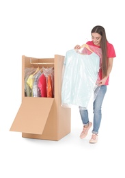 Young woman near wardrobe box on white background