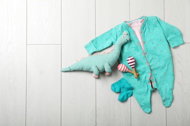 Photo of Stylish baby clothes and toys on wooden background, top view. Space for text