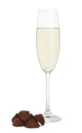 Photo of Glass of sparkling wine and delicious chocolate candies on white background