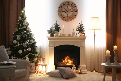 Beautiful room interior with small firs, fireplace and decorated Christmas tree