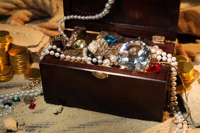 Chest with treasures and scattered sand on floor
