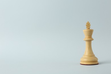 Photo of Wooden king on light background, space for text. Chess piece