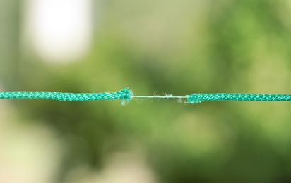 Frayed rope at breaking point against blurred background