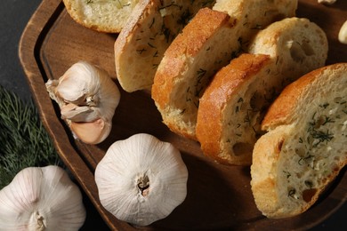 Tasty baguette with garlic and dill on grey table, top view