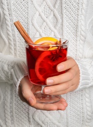 Photo of Woman holding glass with red mulled wine, closeup