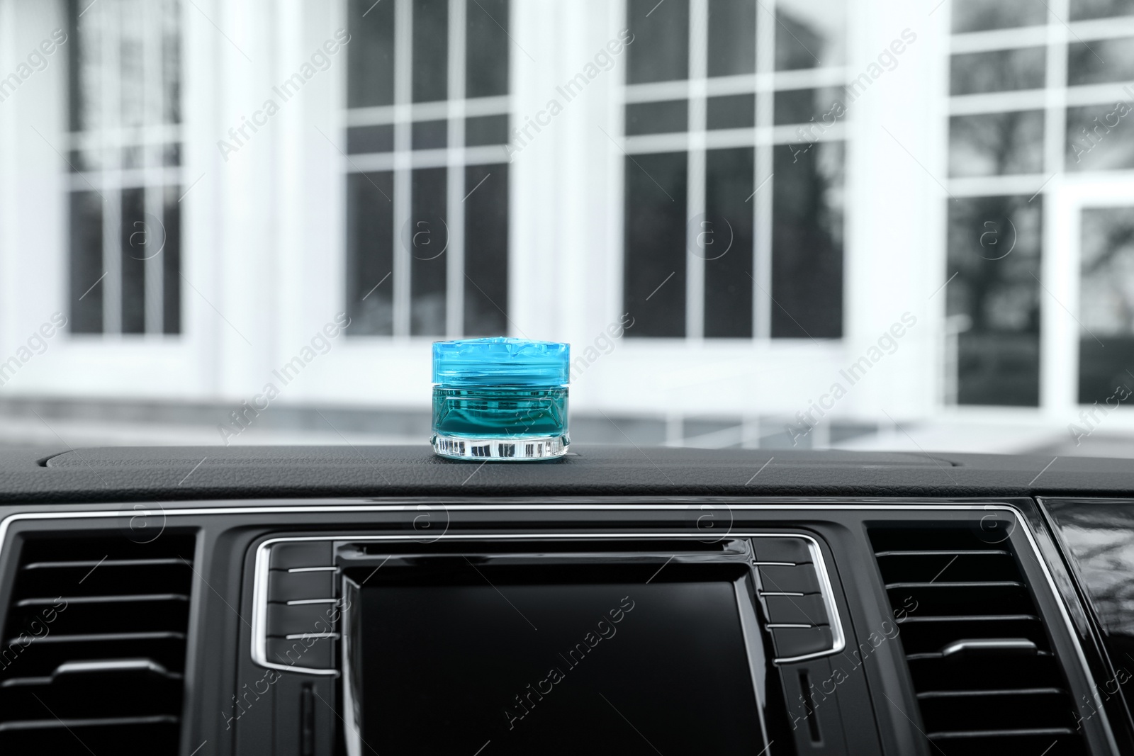 Photo of Stylish air freshener on dashboard in car