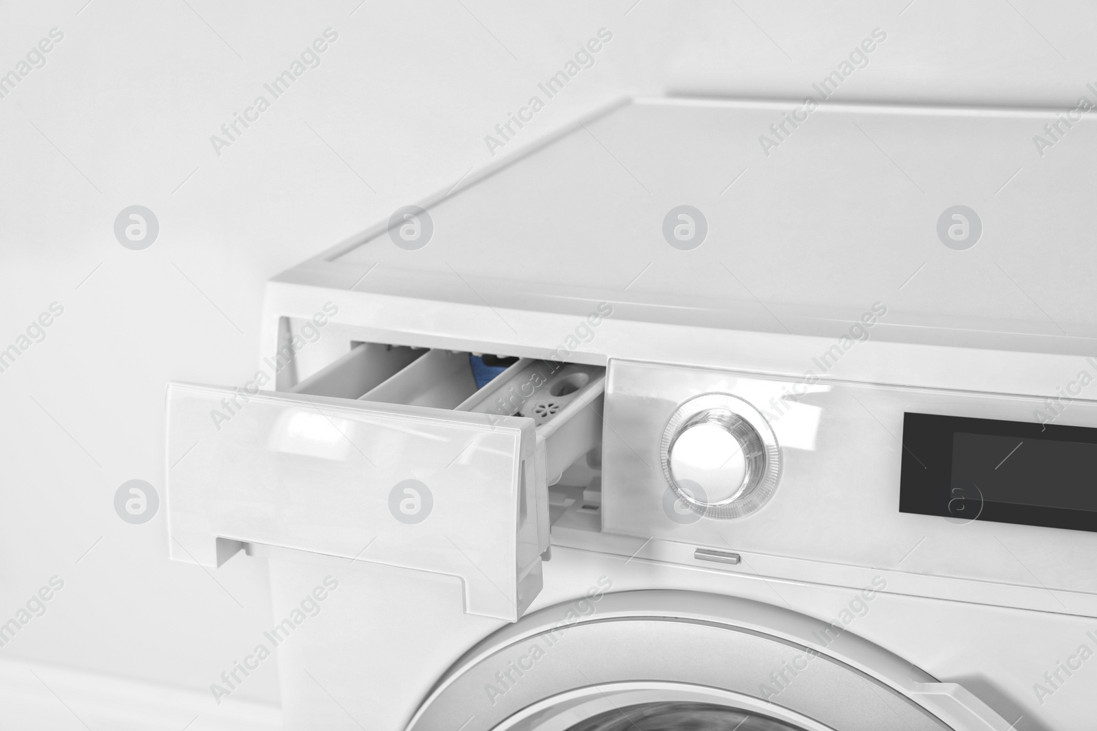Photo of Washing machine with open detergent drawer on white background, closeup. Laundry day