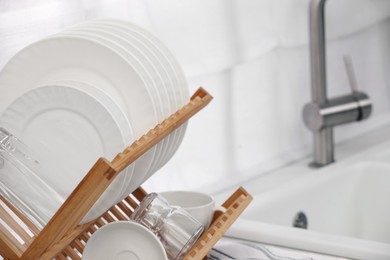 Drying rack with clean dishes in kitchen, closeup. Space for text