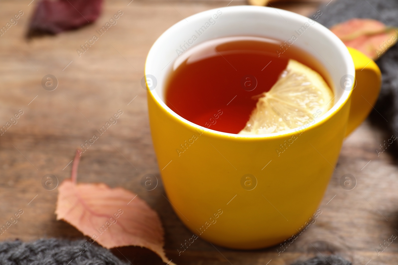 Photo of Cup with hot drink on wooden table, space for text. Cozy autumn