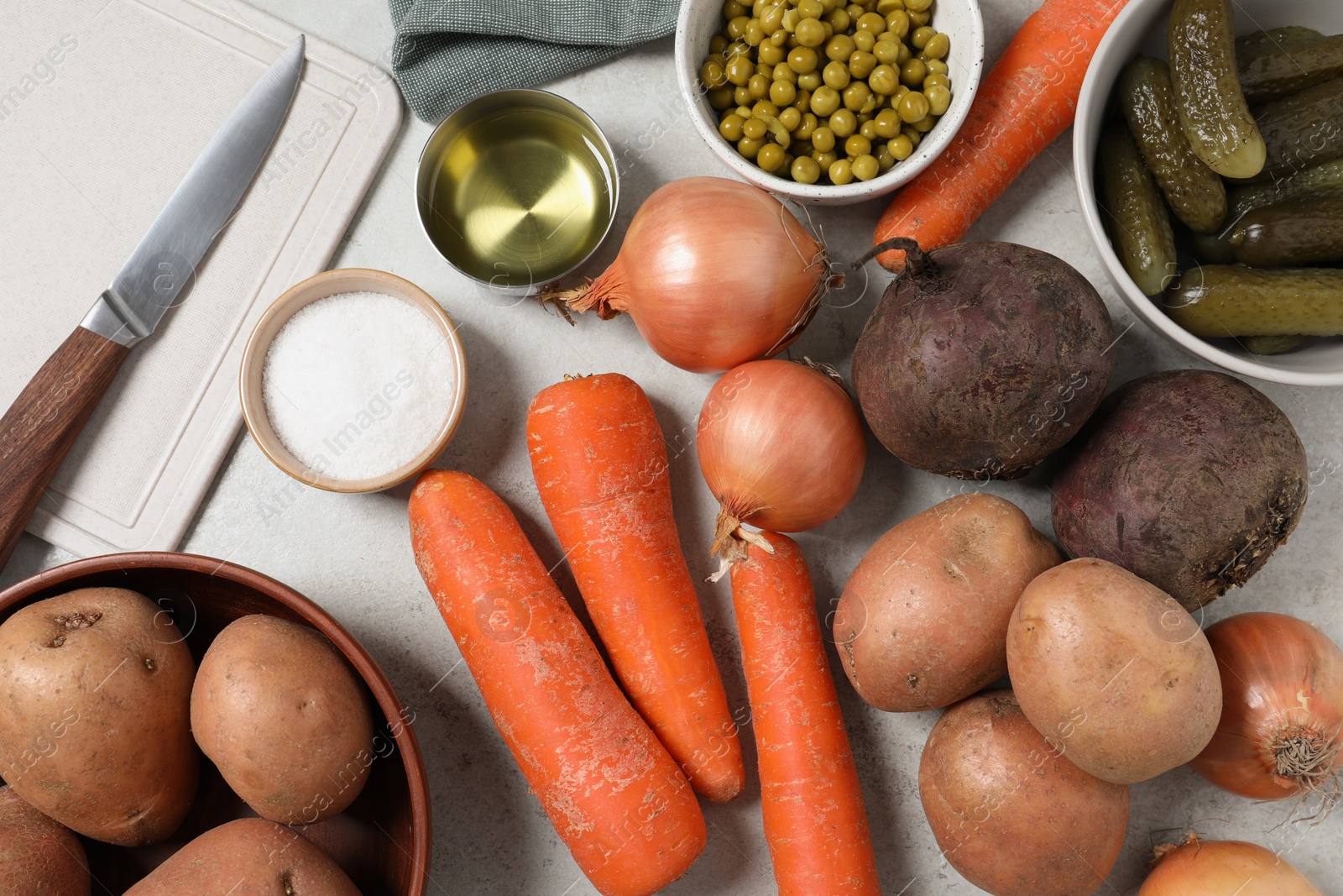 Photo of Many fresh vegetables and other ingredients on white table, flat lay. Cooking vinaigrette salad