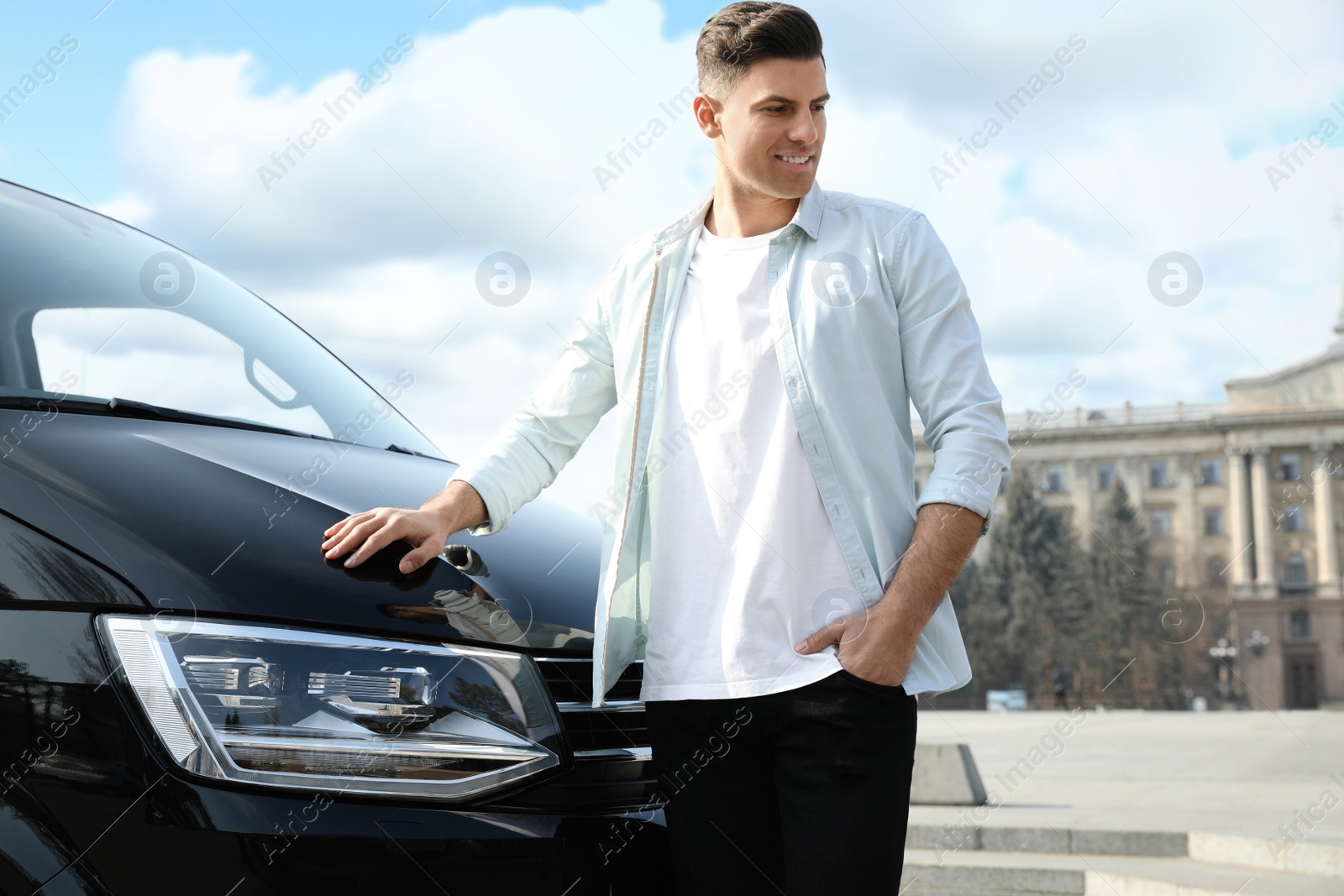 Photo of Handsome man near modern car on city street