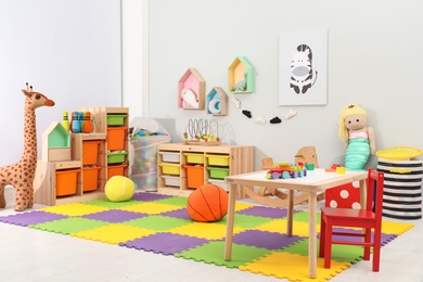 Photo of Cute child's room interior with toys and modern furniture