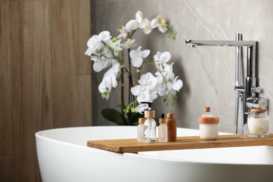 Different personal care products on bath tray indoors