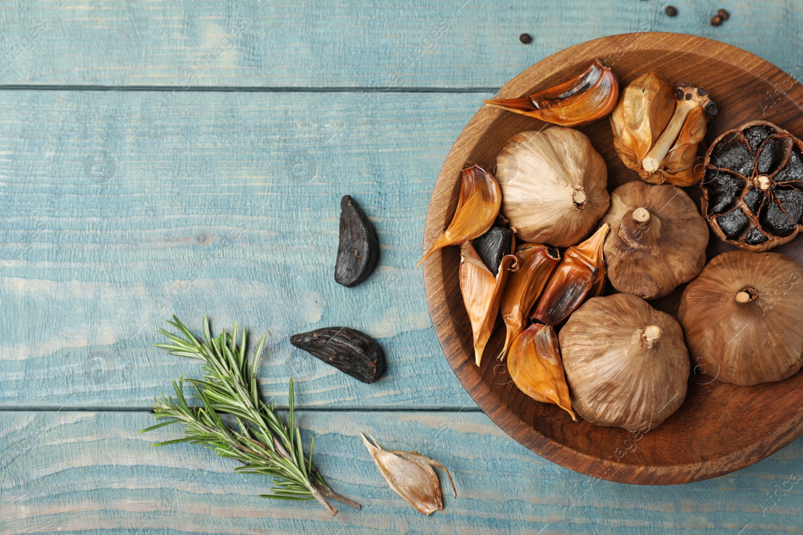 Photo of Flat lay composition with black garlic on blue wooden table. Space for text