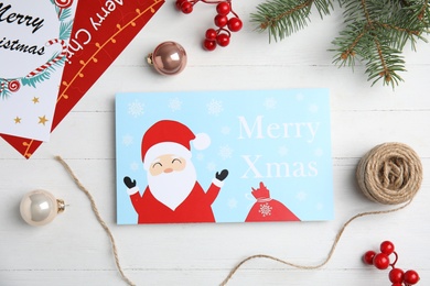 Flat lay composition with Christmas cards on white wooden background