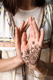 Woman with henna tattoo on palm, closeup. Traditional mehndi ornament