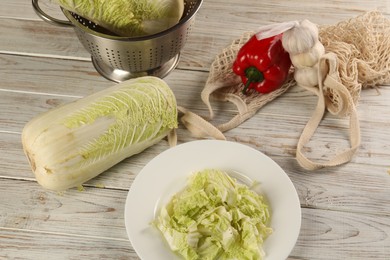 Photo of Fresh Chinese cabbage, bell pepper and garlic on wooden table