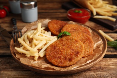 Photo of Delicious fried breaded cutlets served on wooden table