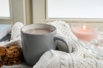 Photo of Cup of hot cocoa on window sill. Winter drink