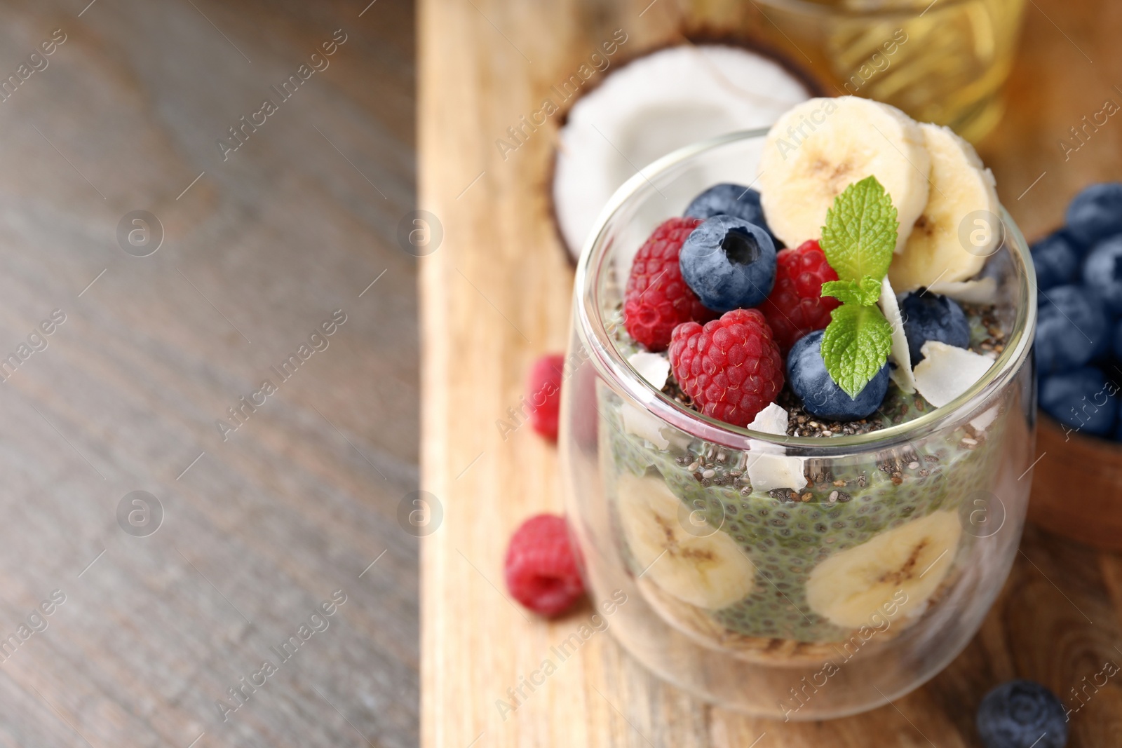 Photo of Tasty oatmeal with chia matcha pudding and fruits on wooden table, space for text. Healthy breakfast