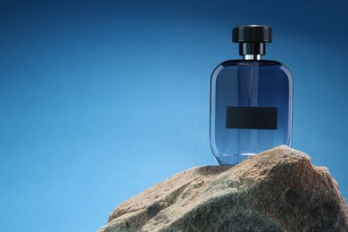 Stylish presentation of luxury men`s perfume on stone against light blue background. Space for text