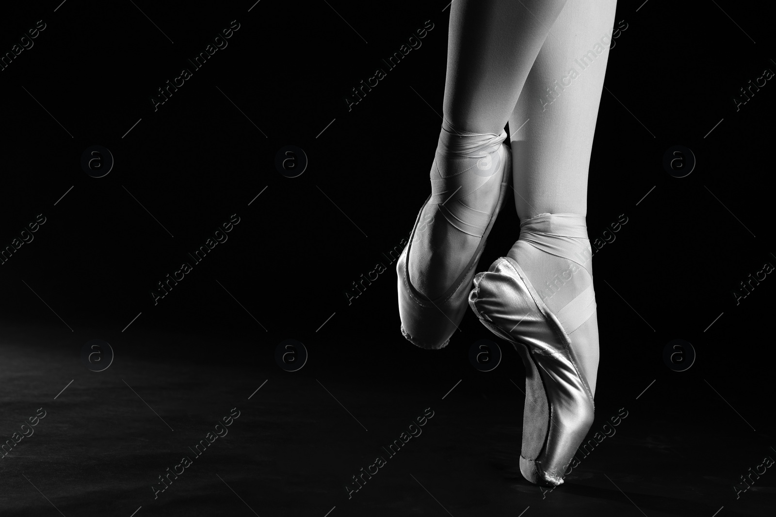 Image of Ballerina in pointe shoes dancing, closeup with space for text. Black and white effect