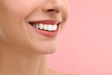 Woman with beautiful lips smiling on pink background, closeup. Space for text