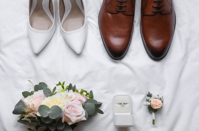 Photo of Flat lay composition with wedding shoes for bride and groom on white fabric