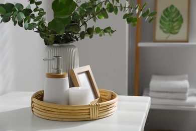 Photo of Vase with eucalyptus branches and toiletries in bathroom, space for text. Interior design
