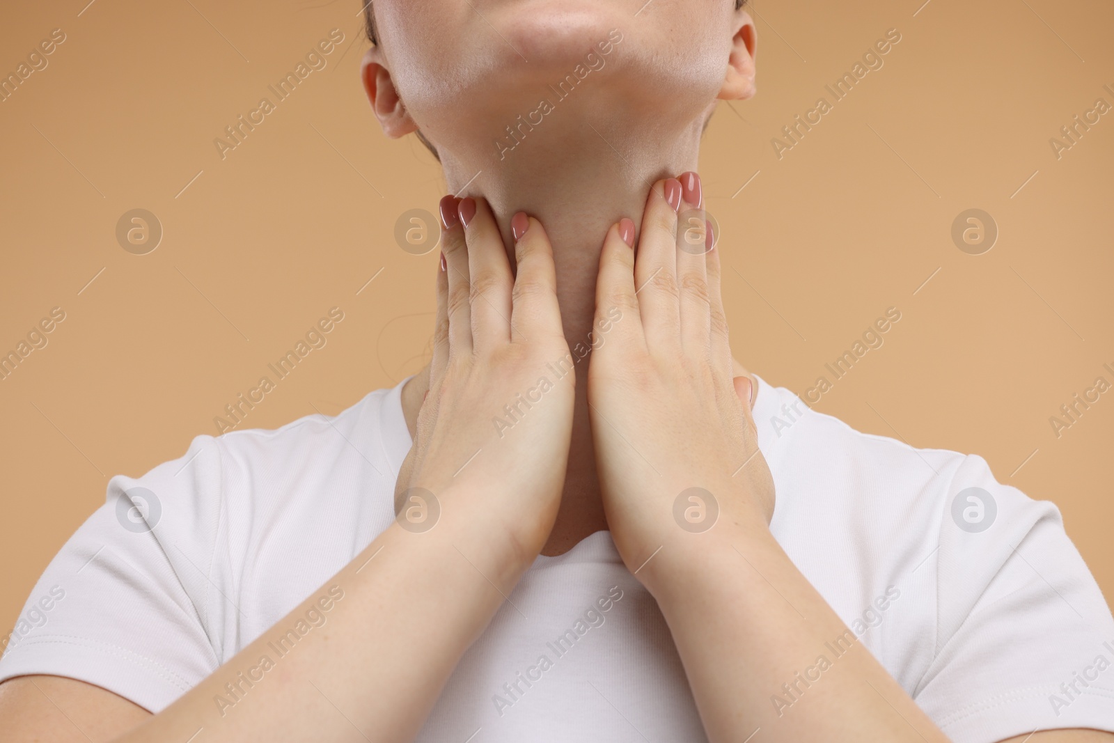 Photo of Woman touching her neck on beige background, closeup