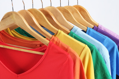 Colorful clothes on hangers against white background