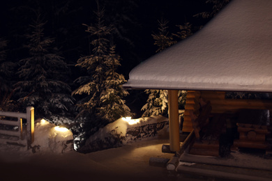 Photo of Wooden gazebo near snowy forest at evening