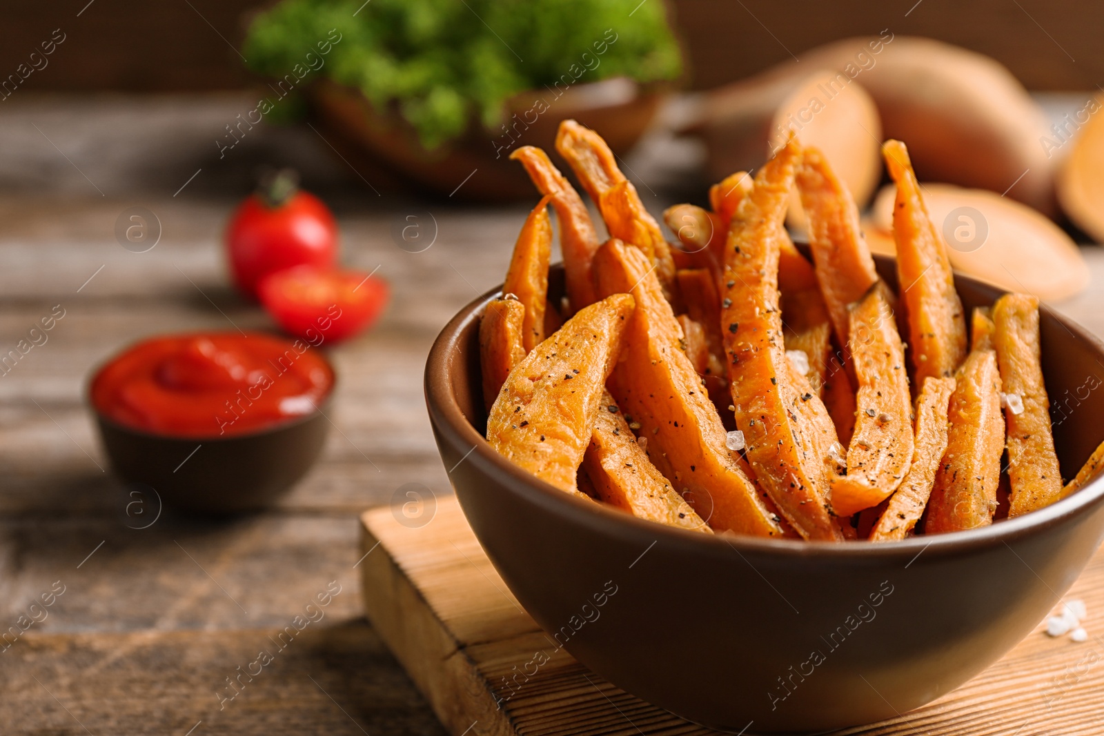 Photo of Bowl with sweet potato fries on wooden table, space for text