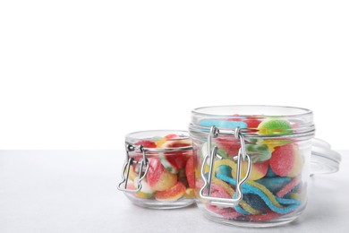 Photo of Tasty jelly candies in jars on light grey table