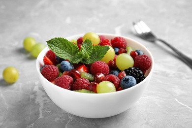 Photo of Fresh tasty fruit salad on grey marble table