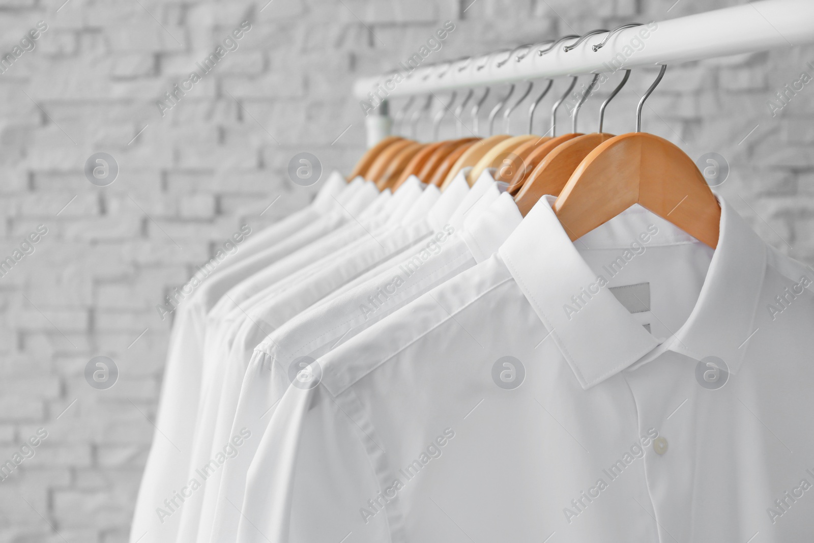 Photo of Rack with clean clothes on hangers after dry-cleaning indoors