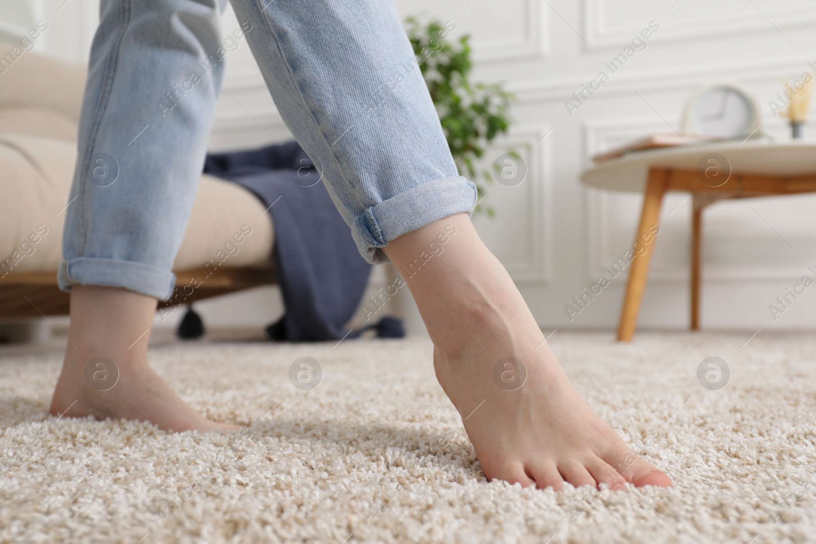 Photo of Woman standing on soft brown carpet at home, closeup