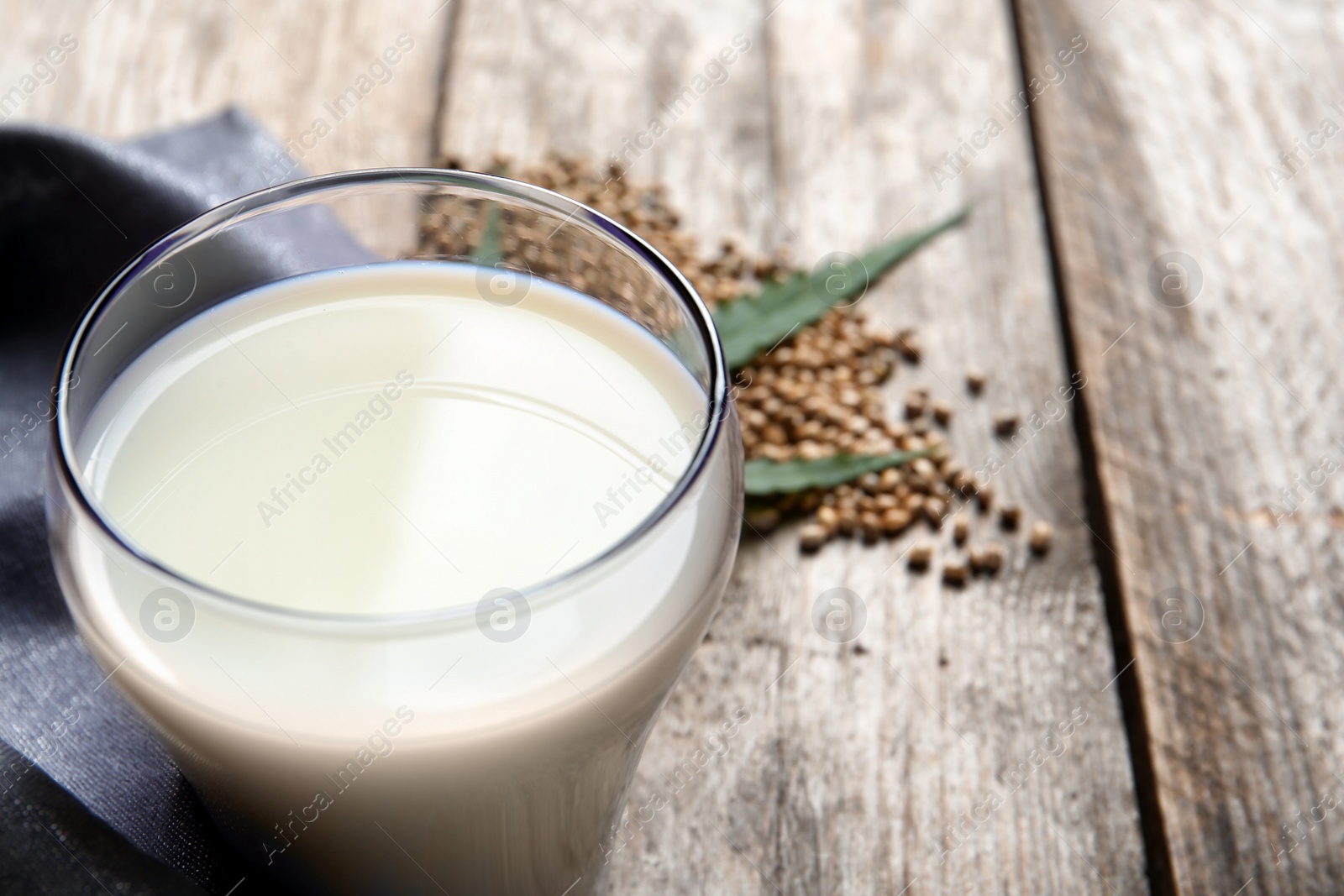 Photo of Glass of hemp milk on table, closeup