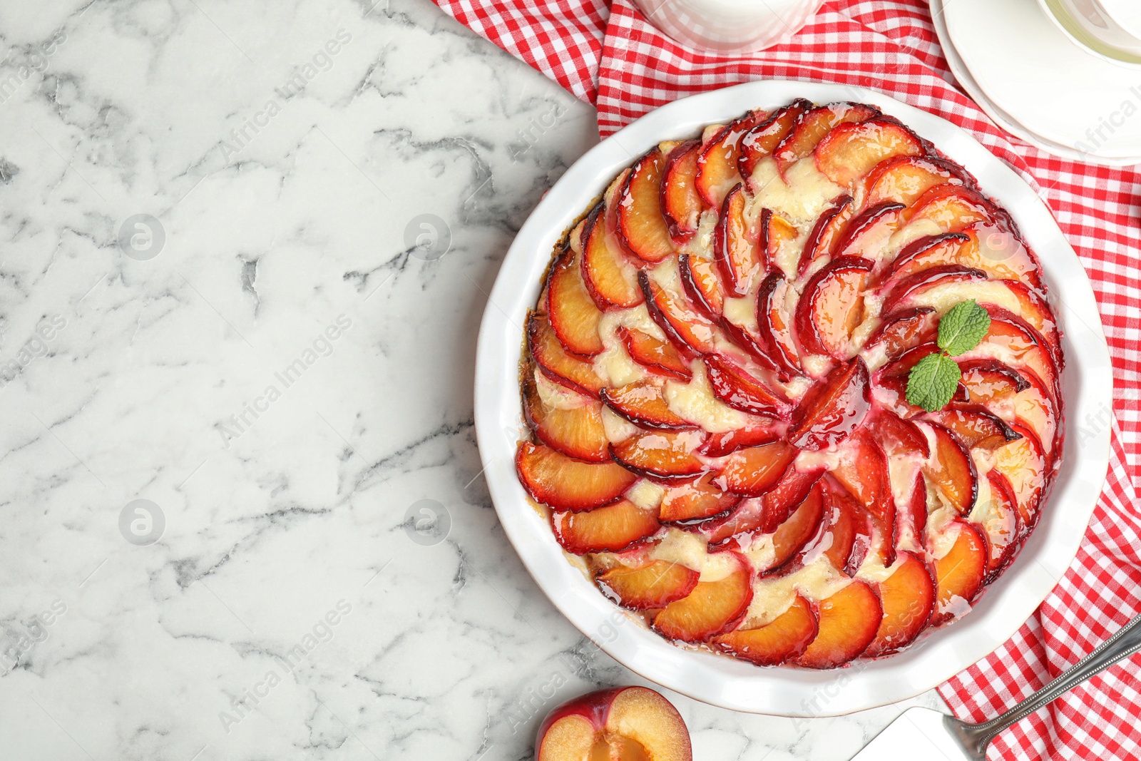 Photo of Delicious cake with plums on white marble table, flat lay. Space for text