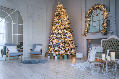 Festive room interior with stylish furniture and beautiful Christmas tree