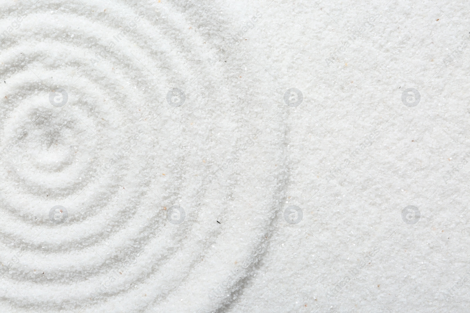 Photo of Zen rock garden. Circle pattern on white sand