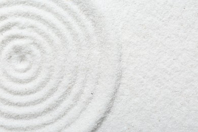 Photo of Zen rock garden. Circle pattern on white sand