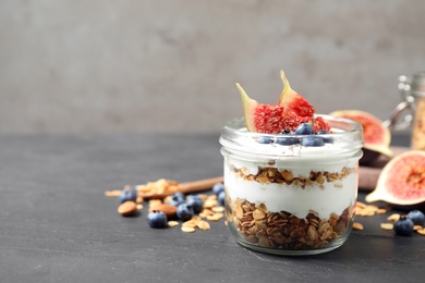 Photo of Tasty homemade granola dessert on dark grey table, space for text. Healthy breakfast