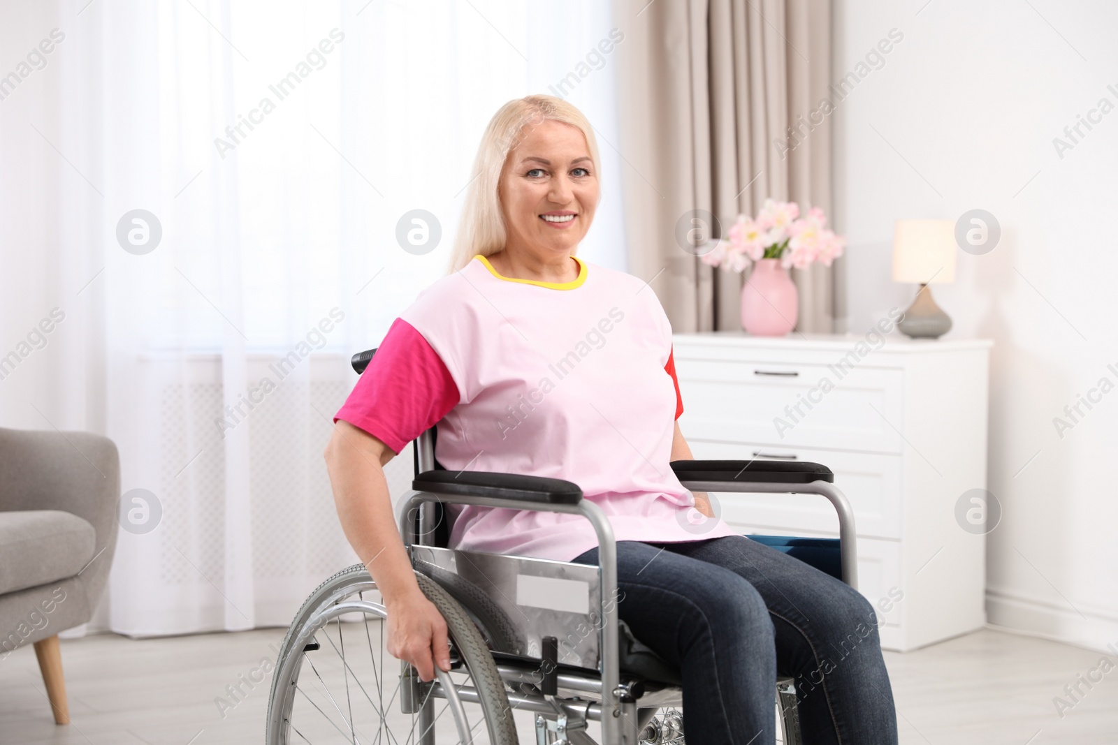 Photo of Mature woman sitting in wheelchair at home