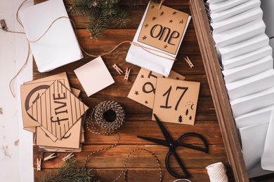 Photo of Flat lay composition with gift bags and fir tree on wooden table. Creating advent calendar