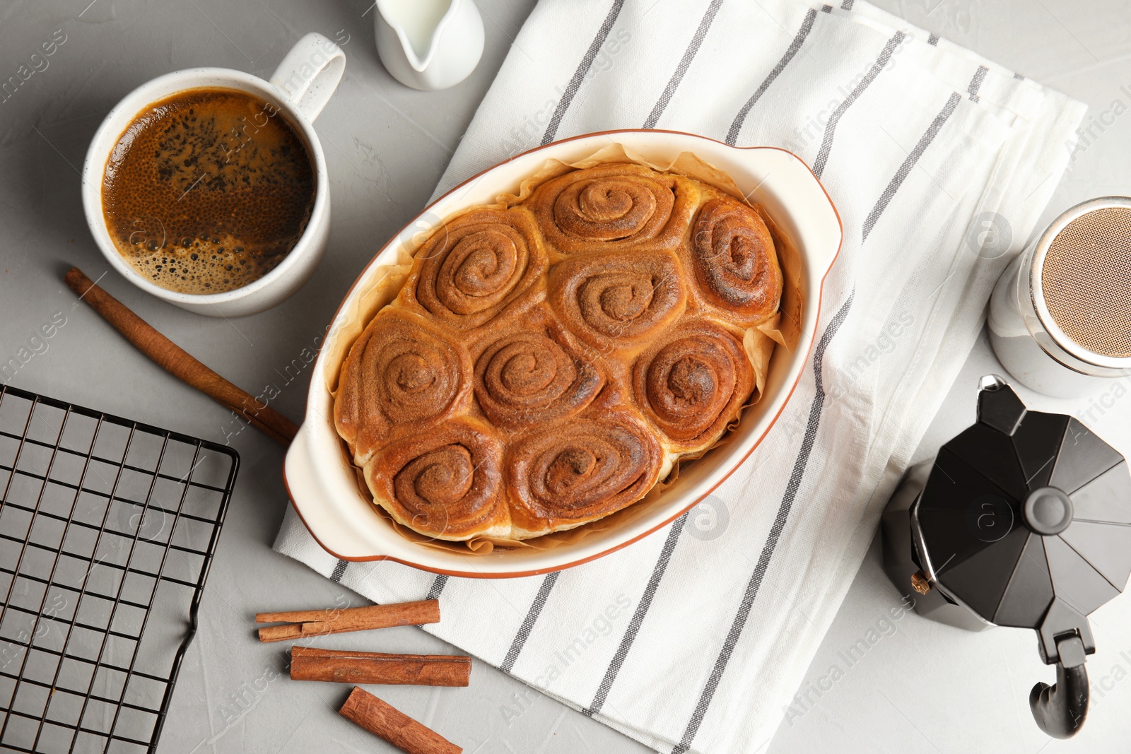 Photo of Flat lay composition with freshly baked cinnamon rolls on grey background