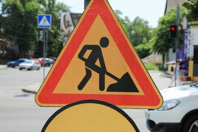 Photo of Road construction sign on city street, closeup. Repair works
