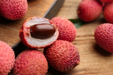 Fresh ripe lychee fruits on wooden table, closeup